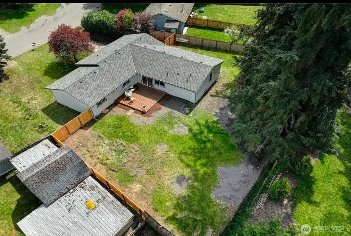 Drone view of the property showing the back deck and yard
