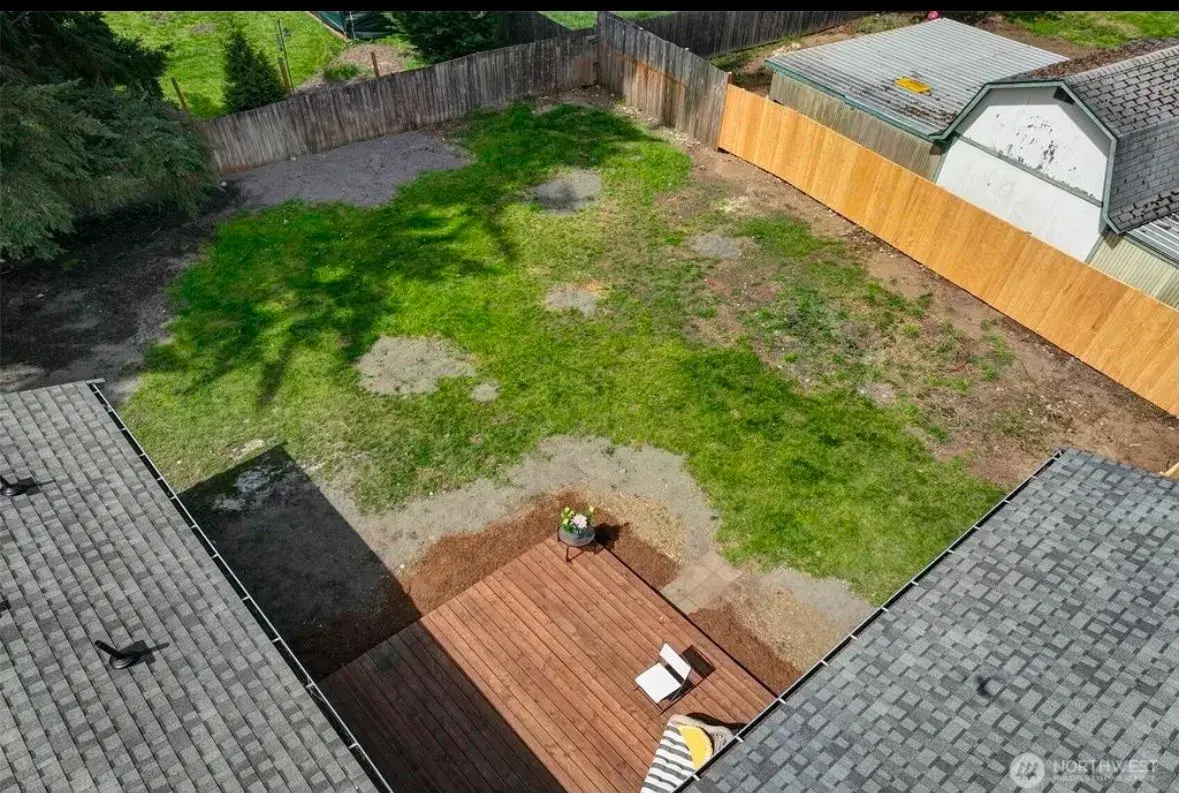 Aerial view of the private backyard, deck, and fenced grounds