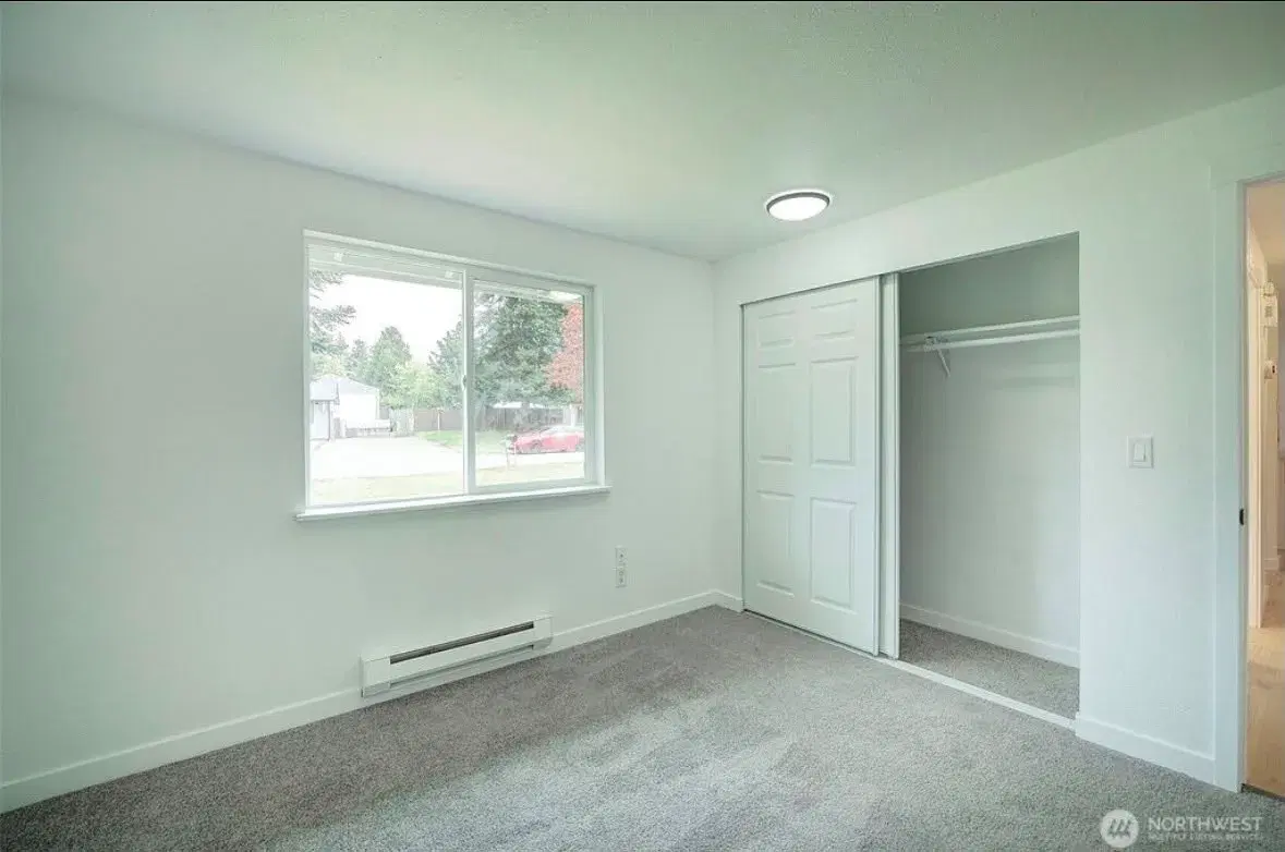 Bright bedroom with closet and street-facing window