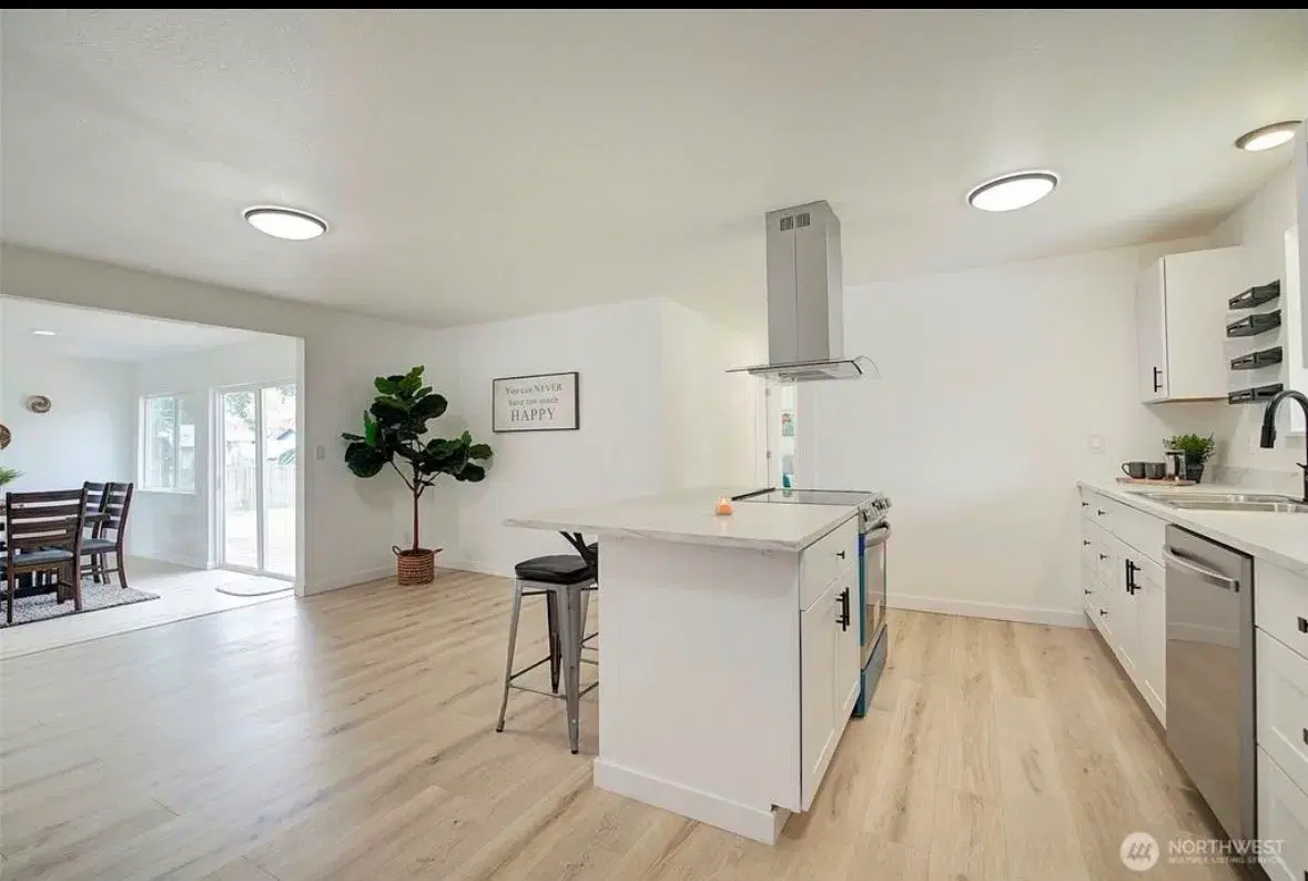 Kitchen island with breakfast bar and stainless steel refrigerator