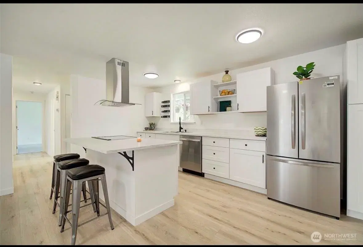 Modern kitchen with island seating and full-size refrigerator