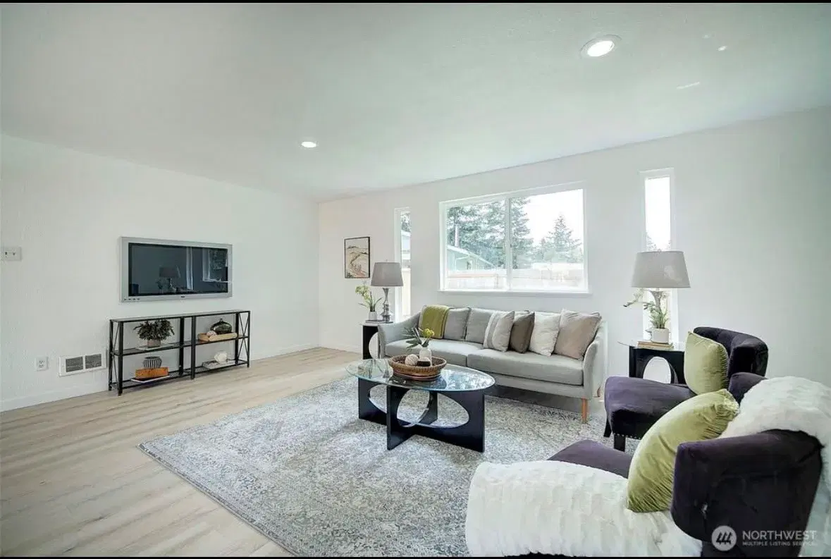 Bright living room with comfortable seating and wall-mounted TV
